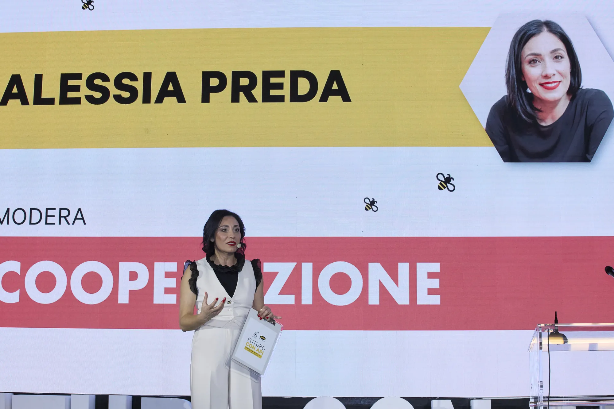 Alessia Preda sul palco Conapi davanti alla parola Cooperazione