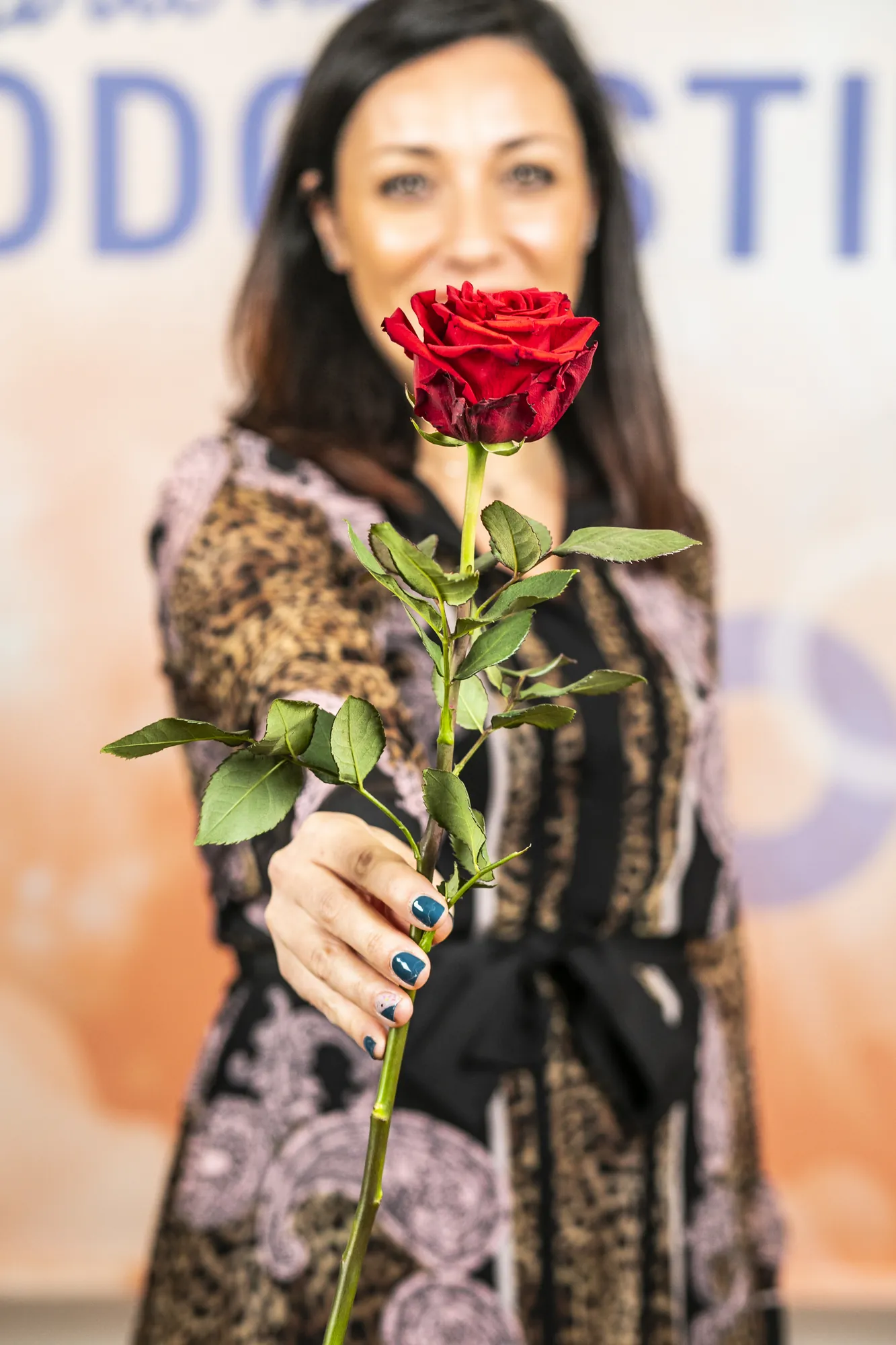 Alessia Preda sorride e tende una rosa rossa verso l’obiettivo al Festival del Podcasting