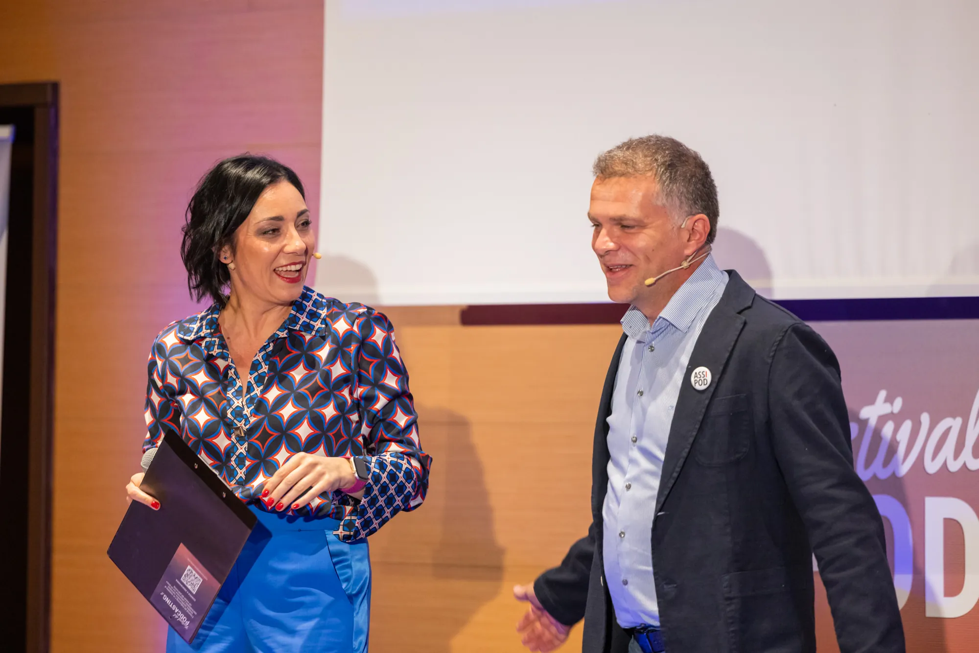 Alessia Preda sorride a un ospite sul palco del Festival del Podcasting