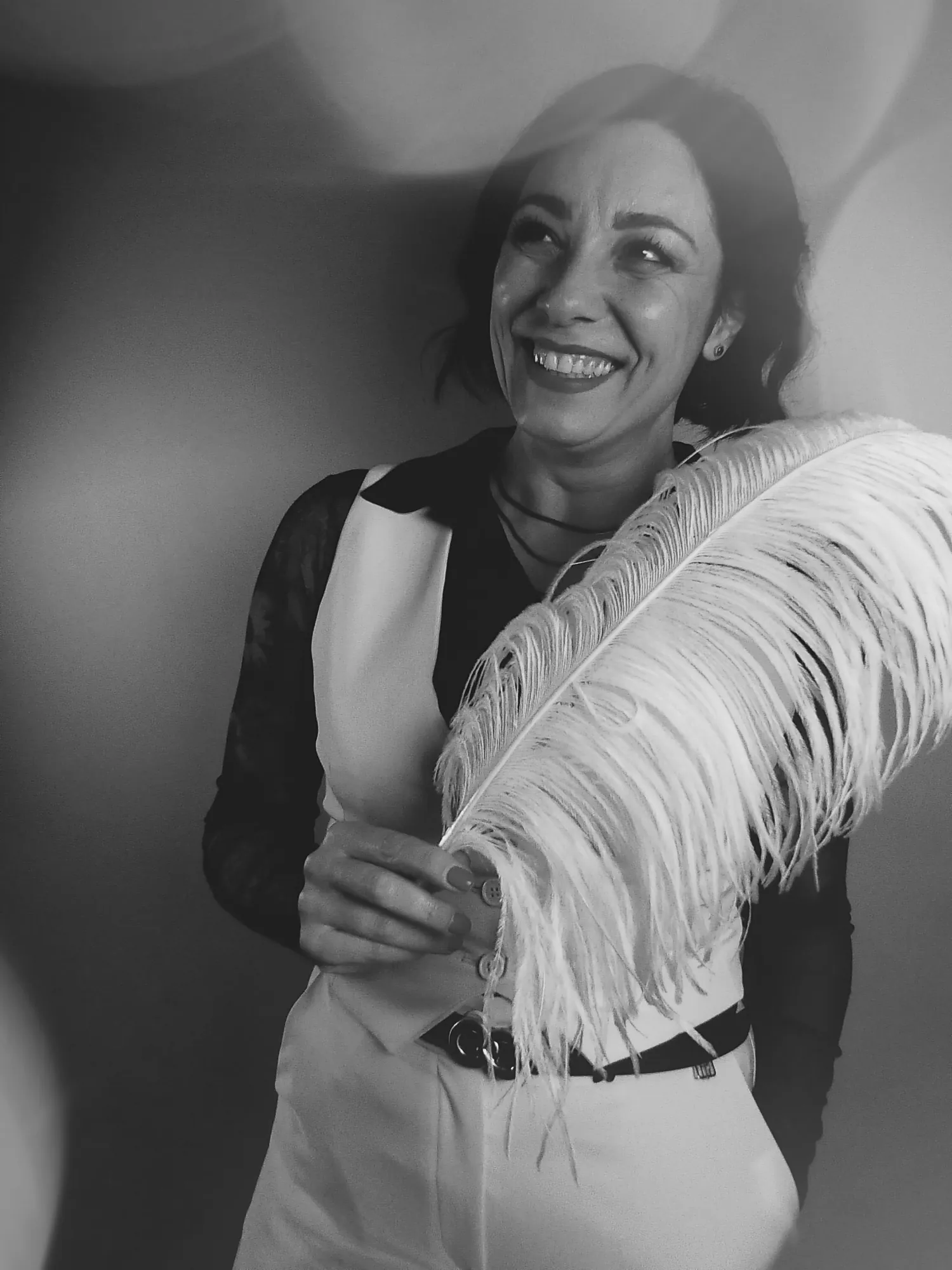 Ritratto in bianco e nero di Alessia Preda con una grande piuma bianca
