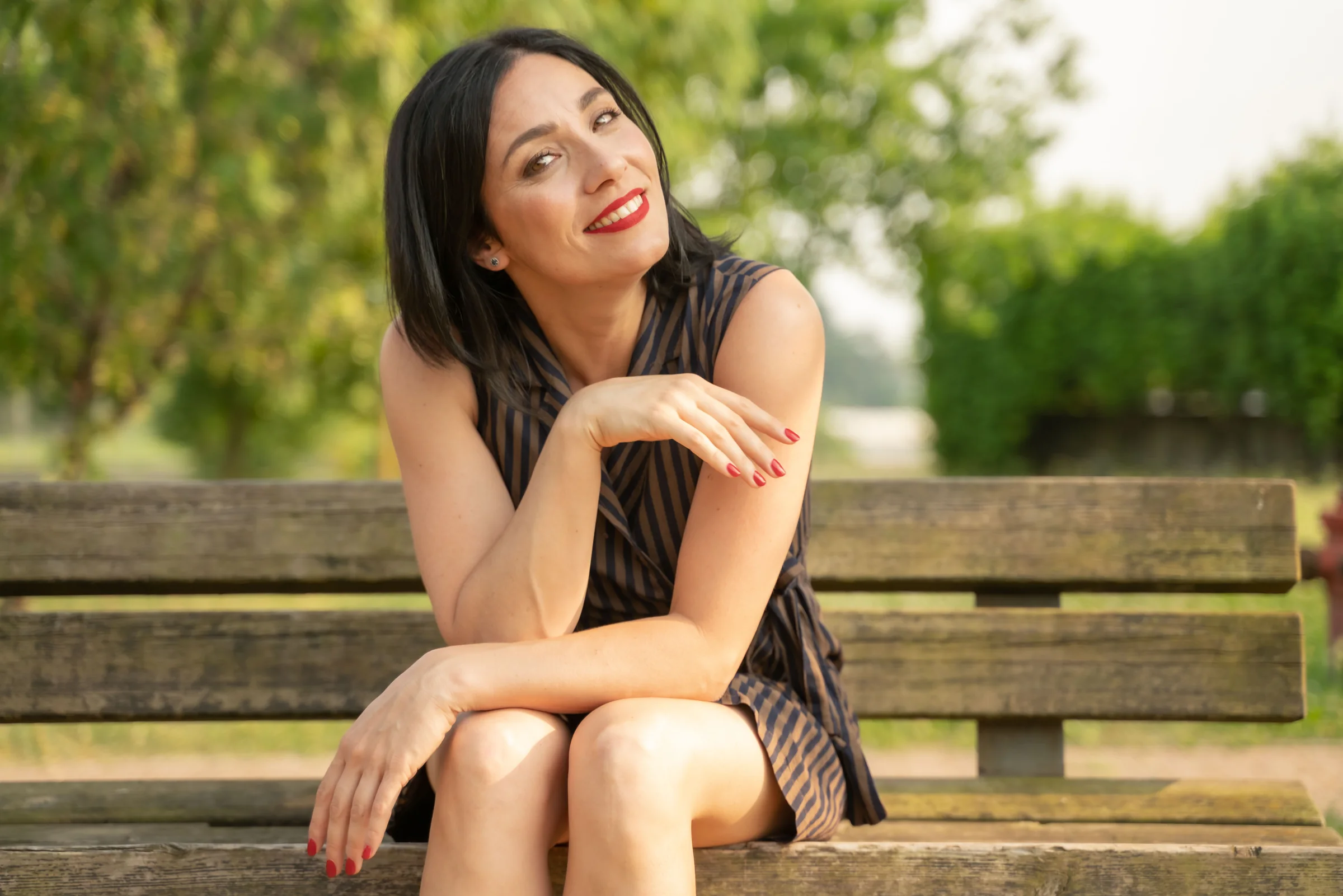 Alessia Preda sorridente, seduta su una panchina nel verde