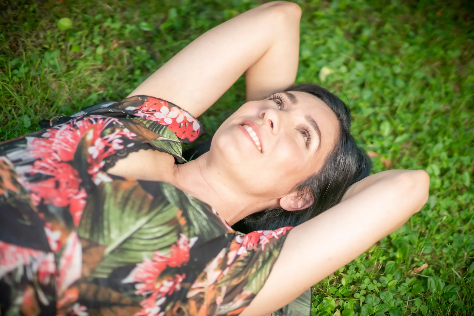 Alessia Preda sdraiata sul prato, con le mani dietro la testa, sorride